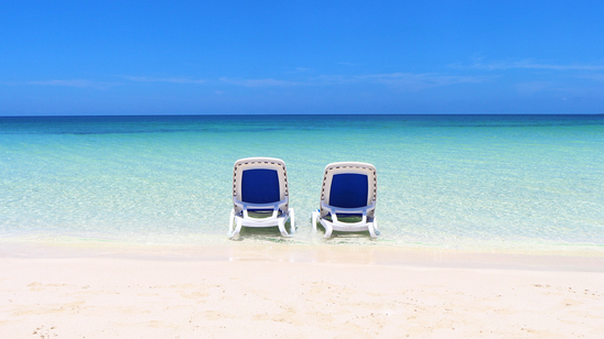 Two loungers are set up in the clear, shallow waters off Cayo Ensenachos&amp