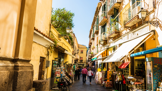 Couple walking on the narrow streets of Sorrento, Italy. Local shops in Sorrento.