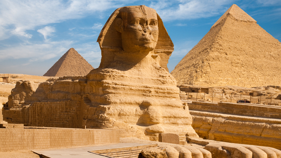 Profile of the Great Sphinx, including pyramids of Menkaure and Khafre in the background, on a sunny day in Giza, near Cairo, Egypt