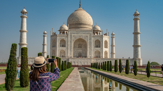 Woman taking photo of Taj Mahal, India